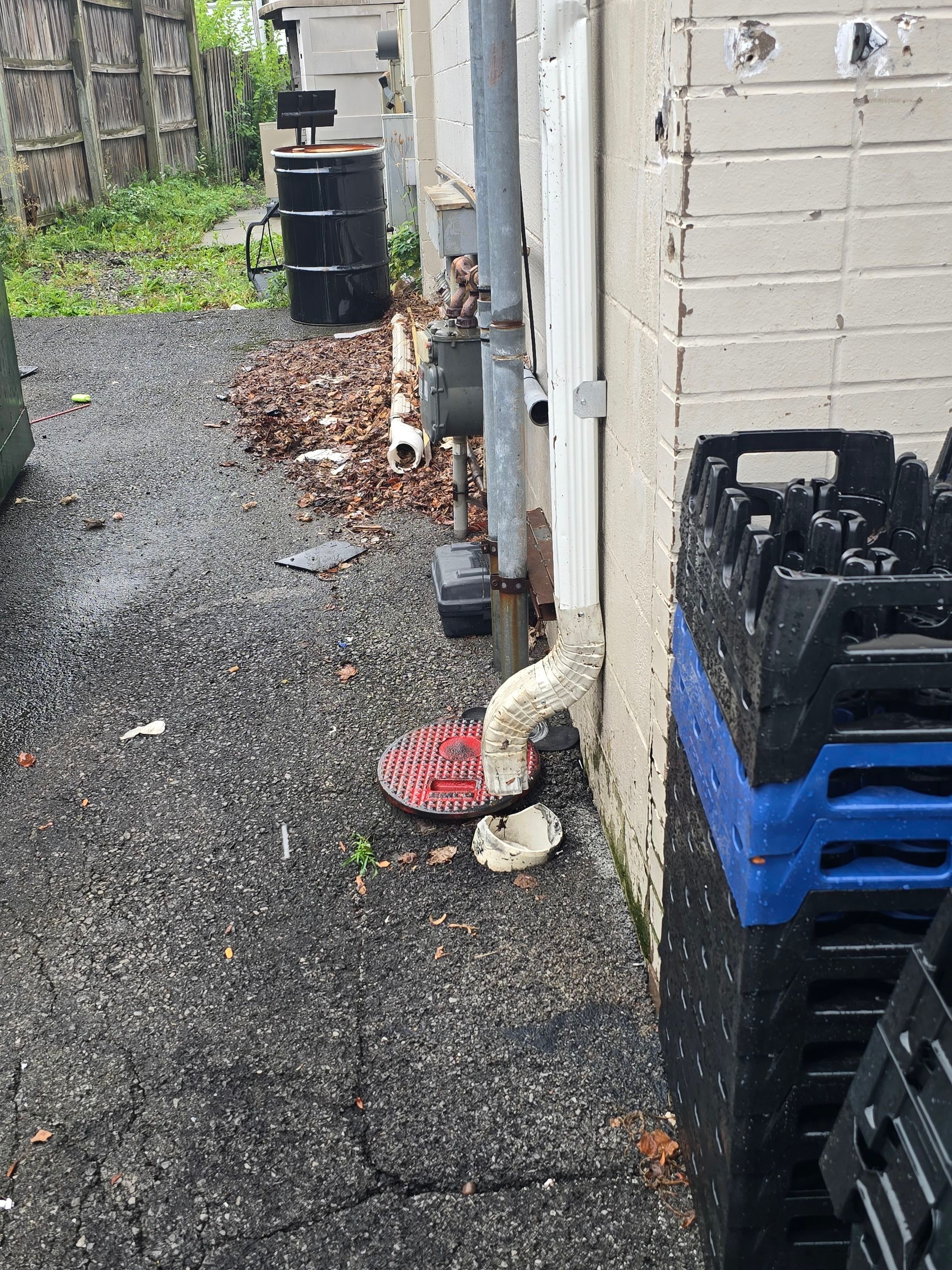 Detached downspout section removed and set on the ground during the repair.