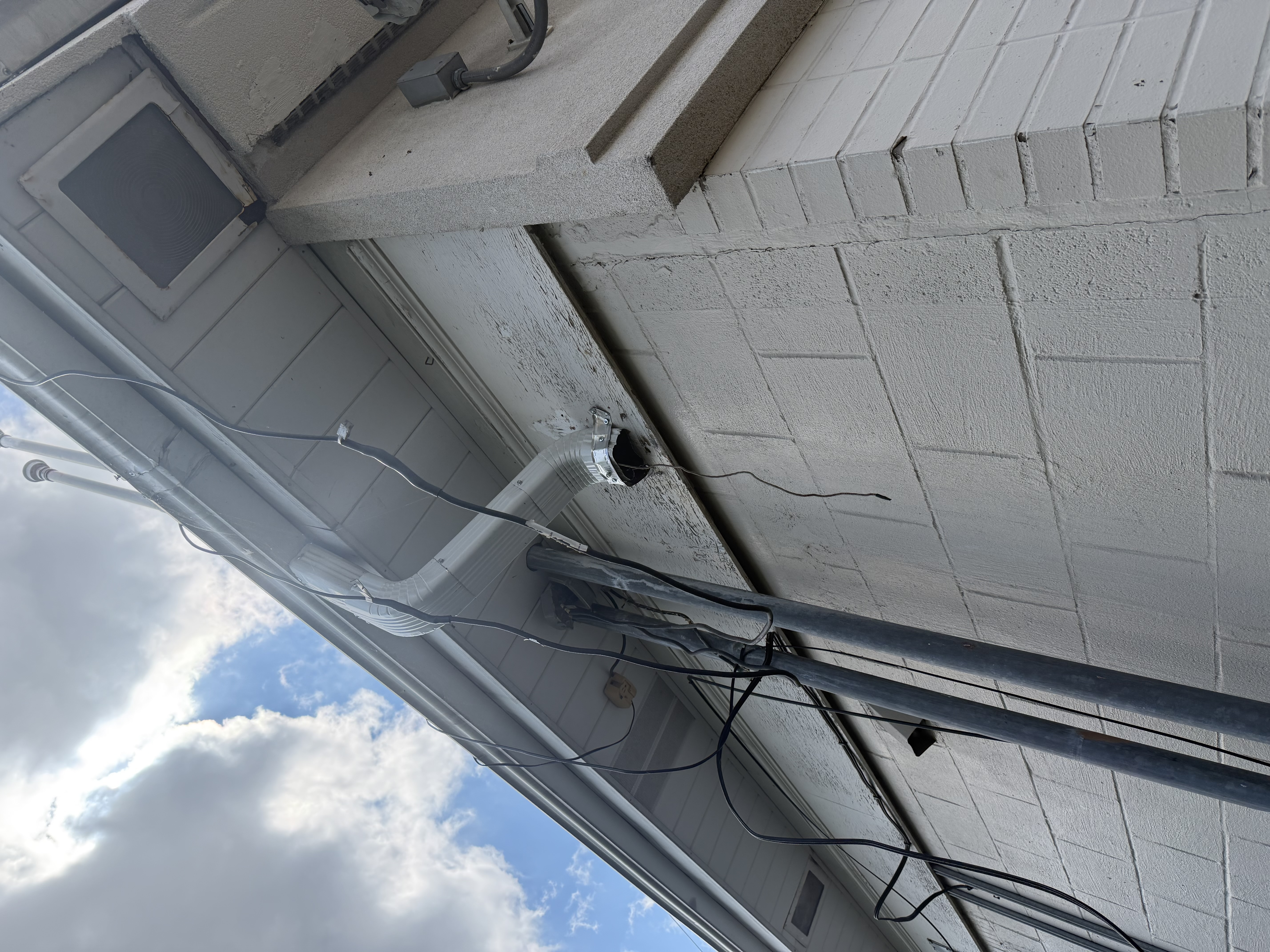 Downspout outlet disconnected at the building eave before repair.
